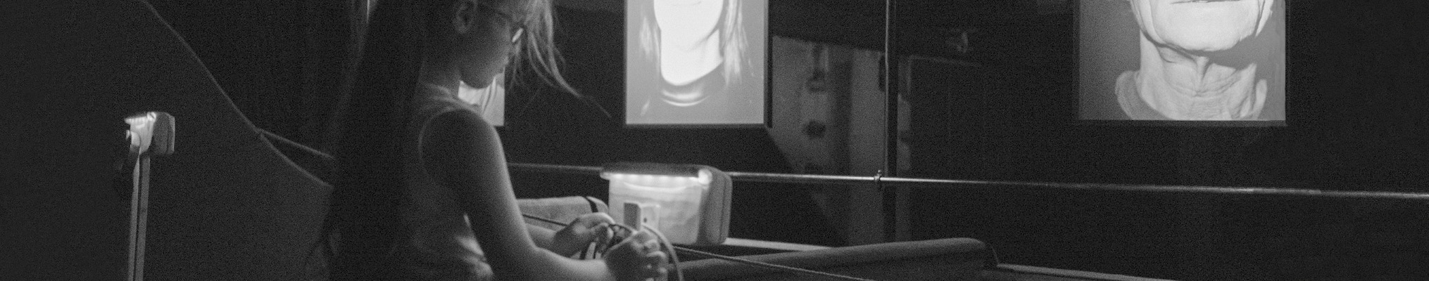 Little girl exploring an exhibition of photo portraits for listening